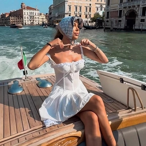 White ruffle mini dress with drawstring detail on a boat in Venice vacation style