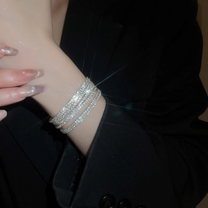 Primo piano di bracciale elastico argento a quattro strati con strass scintillanti