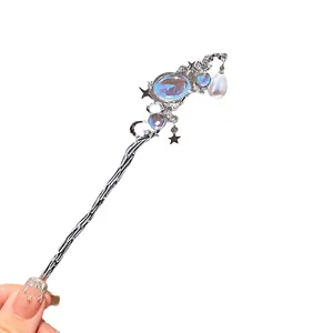 Eleganter silberner Mondstein Haarnadel mit Quasten und Sternen auf weißem Hintergrund