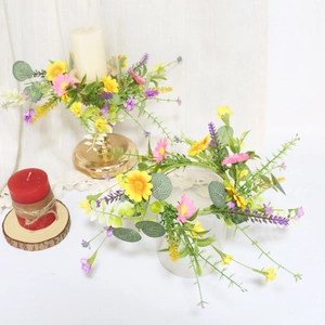 Close-up of artificial floral wreath with yellow daisies and lavender for candle decor