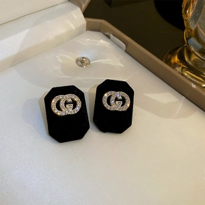 Macro shot of interlocking double G earrings set with sparkling pave-set white zircons