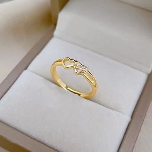 Detail of adjustable gold ring with intertwined heart design and sparkling pavé crystals