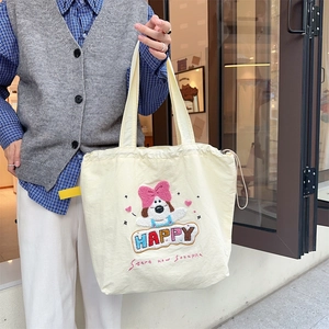 Detail of cute puppy embroidery and artistic lettering on a cream canvas tote bag
