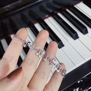 Artistic silver titanium steel bracelet with musical note pendants on piano keys