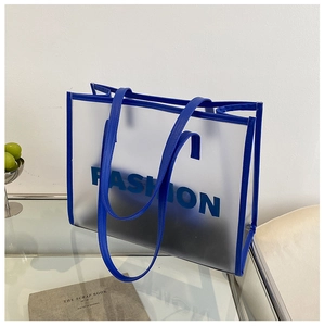 Close-up of blue frosted semi-transparent PVC tote bag with leather handles and fashion logo