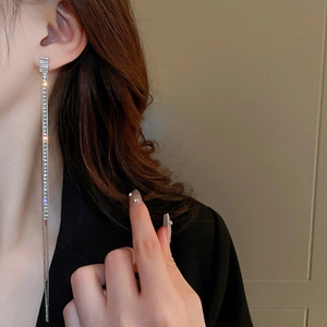 Elegant silver tassel earrings with sparkling zircon crystals shown on a female model