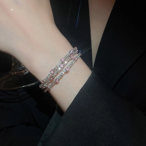 Detail of three-layer silver bangle with alternating pink and white zircons on wrist