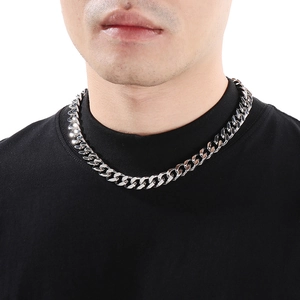 Close-up of silver Cuban link chain necklace worn over a black t-shirt for men