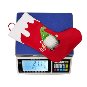 Detailed view of 21.1g Christmas gnome stocking on weight scale showing product dimensions