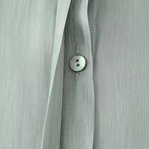 Elegant light green satin shirt for women featuring a glossy shell button detail