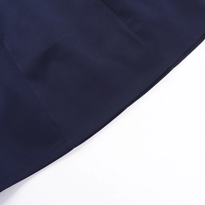 Macro shot of dark blue dress fabric showing fine texture and professional stitching detail