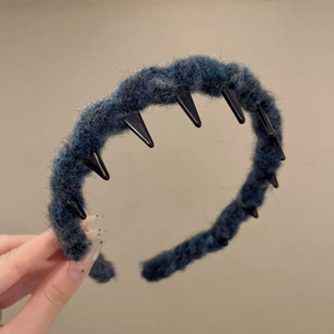 Detail showing deep blue knitted texture and black plastic inner teeth of the headband