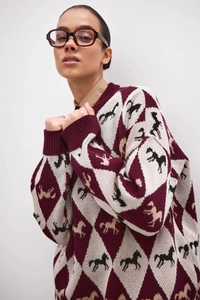 Macro view of argyle knit sweater texture featuring horse silhouette patterns in burgundy