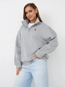 Detail of grey zip-up sweatshirt with heart embroidery and high neck collar style