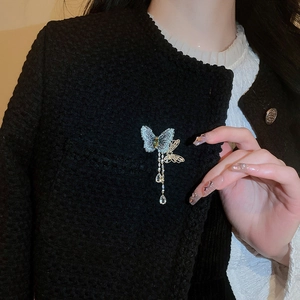 Elegant butterfly tassel brooch with blue wings and crystals on black tweed jacket