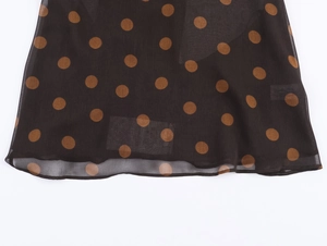 Close-up of black and brown polka dot georgette fabric with fine hemmed edges