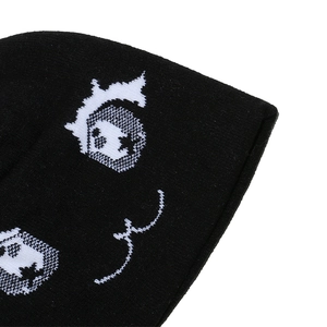 Détail macro du tricot texturé et motif de dessin animé urbain sur ce bonnet noir d'hiver