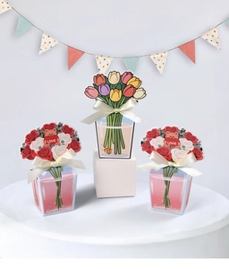 Close-up of tulip and rose themed paper gift boxes with silk ribbon bows for parties