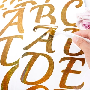 Close-up of peeling gold glitter letter A sticker for DIY wedding and party decor