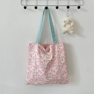 Pink quilted floral tote bag with plush lamb pendant and embroidered brand label