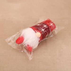 Detail of a Christmas gnome plush with a red knit hat featuring snowflakes in clear packaging