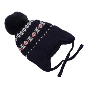Detail of navy knit winter hat for boys with geometric patterns and faux fur pompom