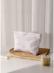 Pink swan jacquard cosmetic bag with zipper on wooden stand with candle and lipstick