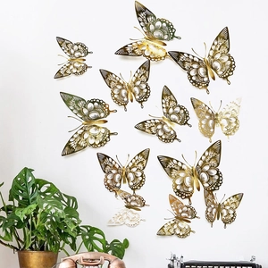 Detailed macro view of 12 golden hollow 3D butterfly wall stickers on a white wall surface