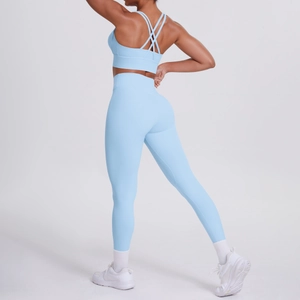 Dettaglio del set yoga azzurro con spalline incrociate e leggings a vita alta