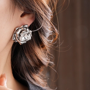Gros plan d'une boucle d'oreille rose argentée avec cristal carré sur l'oreille du mannequin