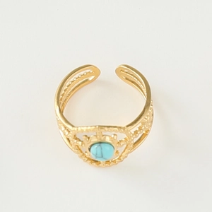 Detail of bohemian gold open ring featuring hollow carvings and a round turquoise stone