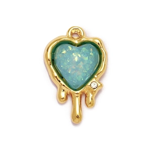 Detail of blue heart pendant with melting gold edge and small crystal accent