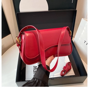 Close-up of red luxury synthetic leather shoulder bag with adjustable strap and flap