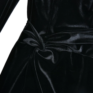 Gros plan sur le velours noir élégant montrant le nœud à la taille et les plis fins