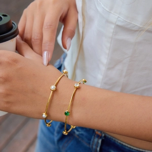 Set di bracciali in acciaio inossidabile dorato 18K con perle indossati da una modella