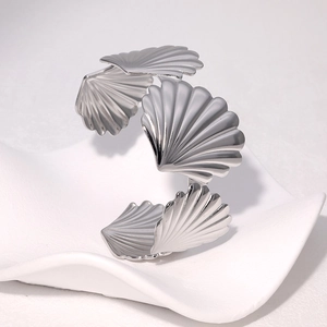 Macro view of silver scallop shell cuff bracelet with polished metallic texture
