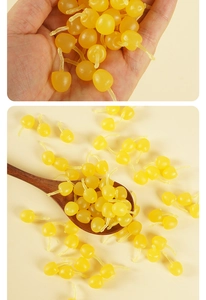 Detailed close-up of mini yellow PVC cherry beads with stems for DIY craft materials
