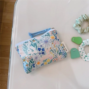 Detail of floral cotton mini pouch with rabbit print and blue woven zipper puller