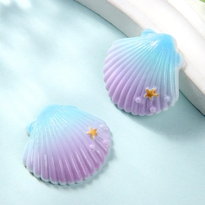 Close-up of resin shell charms with blue-purple gradient and gold starfish detail
