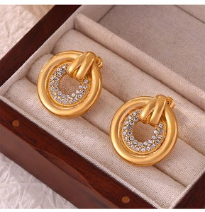 Close-up of golden round earrings with double circle micro-pave crystals in a box