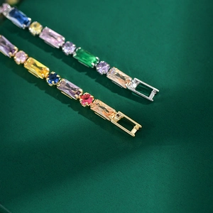 Macro detail of rainbow zircon tennis bracelet featuring gold and silver prong settings
