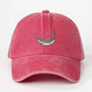Close-up of embroidered shark patch on red washed cotton vintage baseball cap