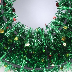 Close-up of green Christmas tinsel garland with red and gold sequin accents for decoration