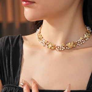 Detail of vintage style necklace with gold metal leaves and small white pearls