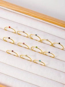 Detailed macro view of thin gold-plated rings with colorful circular zircon settings