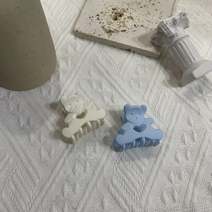Detail of cream and blue matte bear hair claws with heart cutout on stone decor