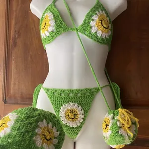 Detail of handmade green crochet daisy bikini set featuring embroidered smiley face flowers