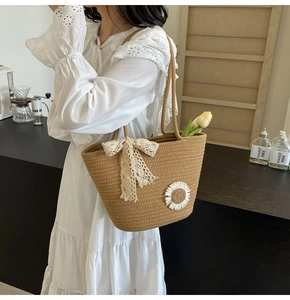 Close-up of woven tote bag featuring a white lace bow and sunflower floral accents