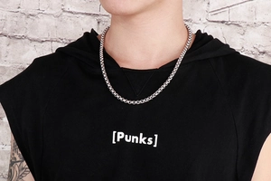 Detail of a punk-style stainless steel chain necklace worn on a male neck