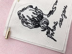 Detailed embroidery texture on a rectangular white patch with black artistic graphics